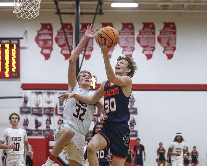 Oswego's Brayden Borrowman (30) is met at the basket by Yorkville's Joey Jakstys (32) during their basketball game between Oswego at Yorkville Friday, Dec 12, 2025 in Yorkville.