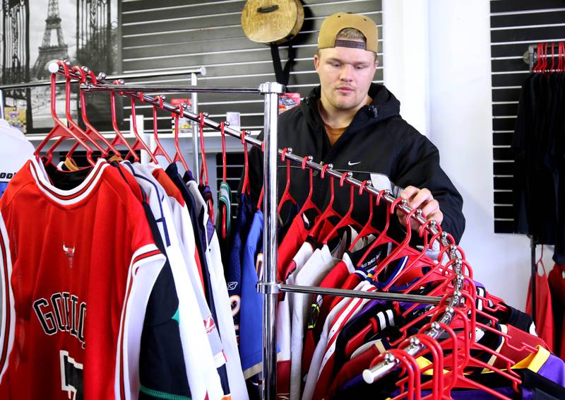 SommsVintage owner Jordan Sommers organizes some of the jerseys he has available Wednesday, Nov. 27, 2024, ahead of Small Business Saturday at the store in DeKalb. Many locally owned shops are gearing up for Small Business Saturday which is November 30th.