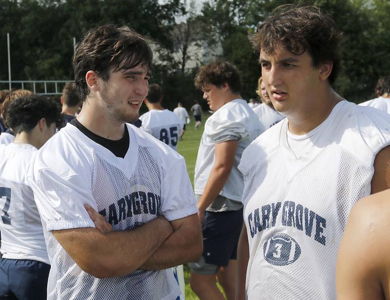 Cary-Grove's Logan Abrams and Andy Bolf discuss plays during Cary-Grove’s first football practice of the upcoming season on Monday, August 11, 2025, at Cary-Grove High School.