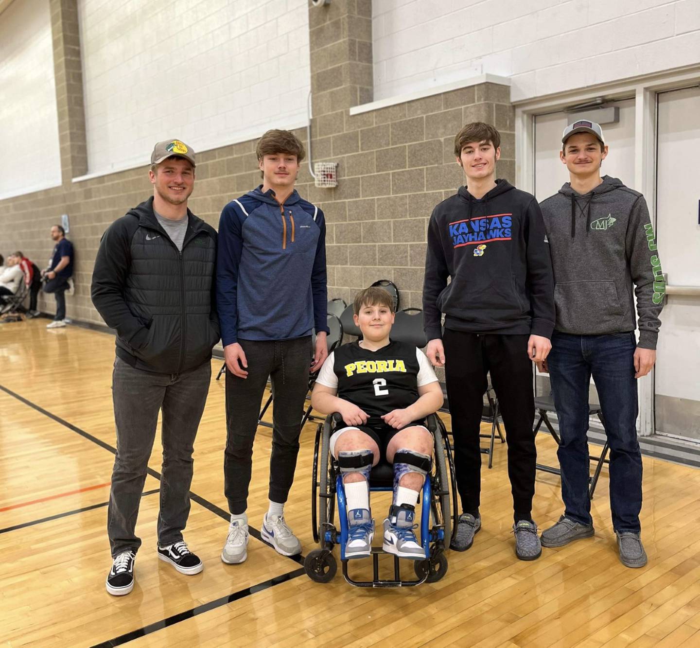 Zane Britton, 10, of Princeton got a visit from PHS seniors Teegan Davis and Grady Thompson along with Drake Davis (left) and Cael Davis (right) while playing for the Peoria Wildcats during the IHSA Wheelchair State Tournament in Champaign Saturday.