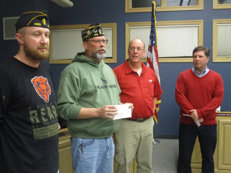 Yorkville American Legion Post 489 Commander Anthony Cella thanks the city of Yorkville for a $2,500 check, proceeds from the Flags of Valor display, on Dec. 13, 2022. At left is Legion Adjutant Kyle Nelson. At right are Mayor John Purcell and Parks and Recreation Director Tim Evans.