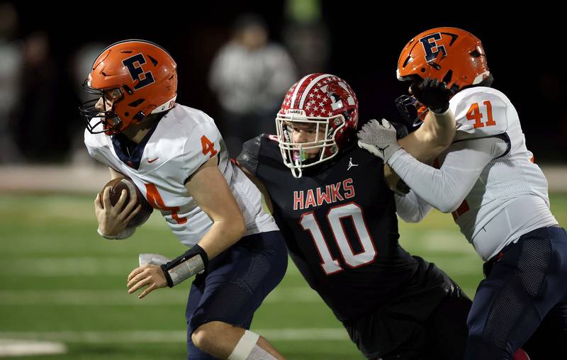 Maine South's Clark Simpson (10) brings down Evanston's Jaxin Moore (4) as Evanston's Cole Robinette (41) tries to stop him Friday October 20, 2023 in Park Ridge.