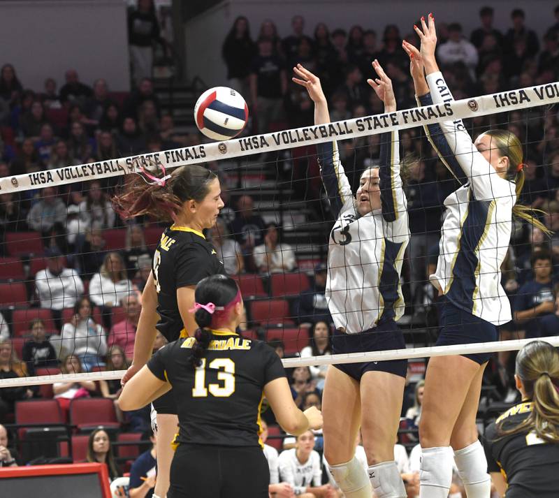 Riverdale's Katie Cox (55) battles two Central Catholic players at the net during the 2A semifinal match with Central Catholic at the state volleyball tournament at Illinois State University on Friday, Nov. 14, 2025.