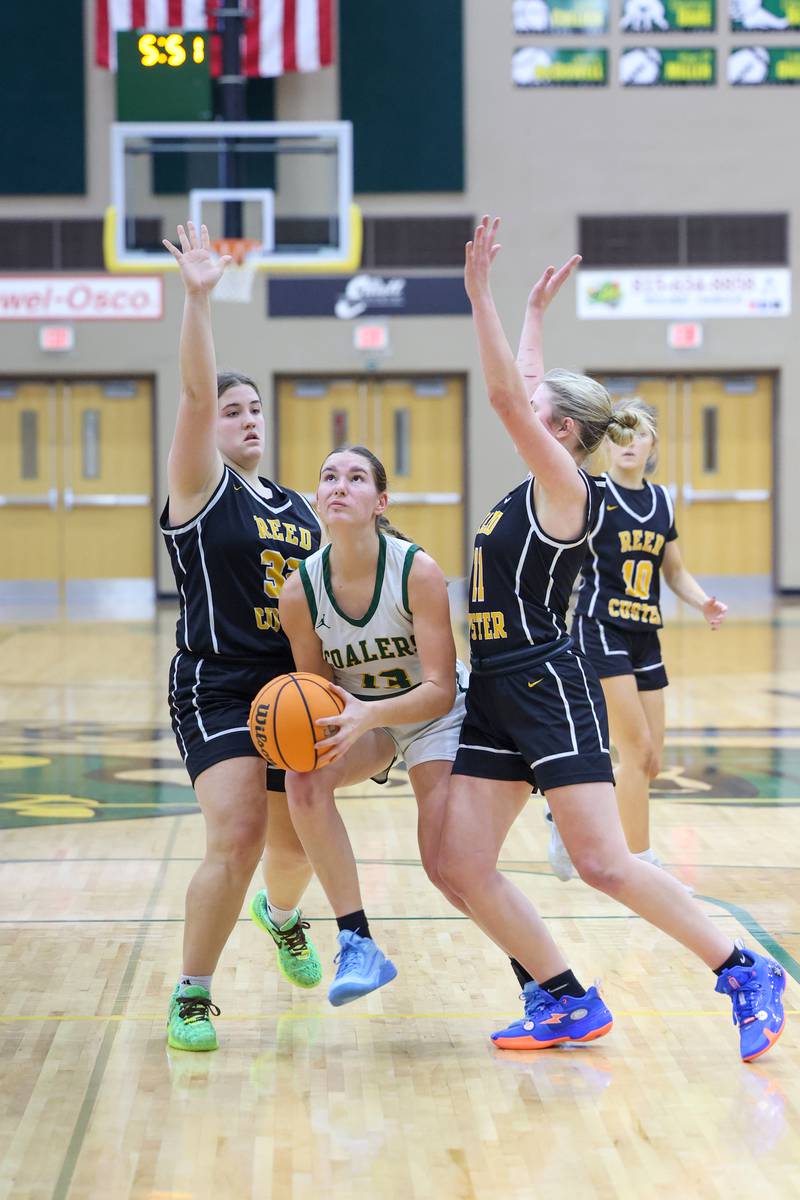 Coal City's Kyla Stark looks to shoot under pressure from Reed-Custer's Harlie Liebermann, left, and Morgan Toler during the Comets' 50-43 victory over Coal City on Monday, Jan. 11, 2026.