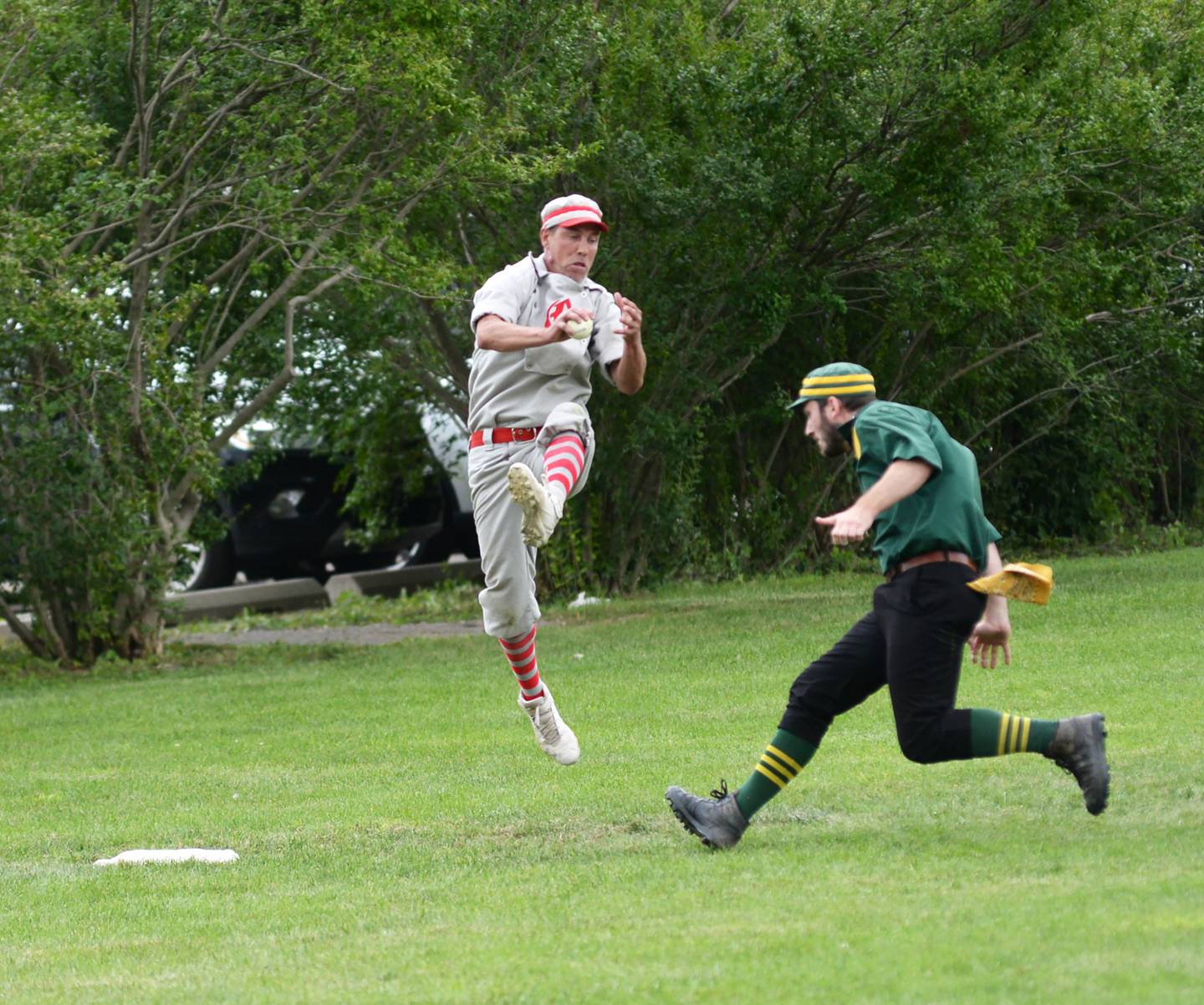 Oregon Ganymede third baseman "Dollar" Bill  Roschi jumps to bring down a high throw before tagging out a Canton runner at the 21st Annual World Tournament of Historic Base Ball in Dearborn, Michigan on Saturday, Aug. 10, 2024.