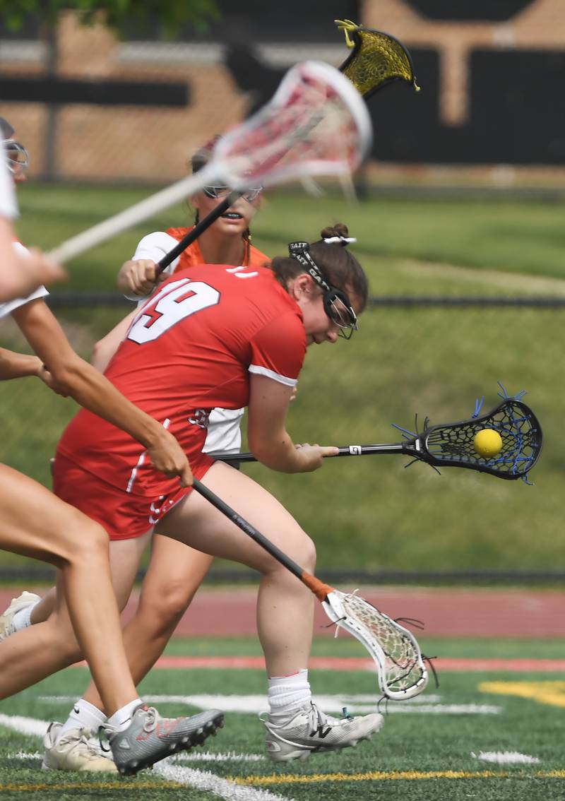 Hinsdale Central's Maggie Conley draws contact from Crystal Lake Central Coop players including Adaline Arliskas, back, just before scoring during the third-place game of the girls lacrosse state finals at Hinsdale Central High School on Saturday, June 7, 2025.