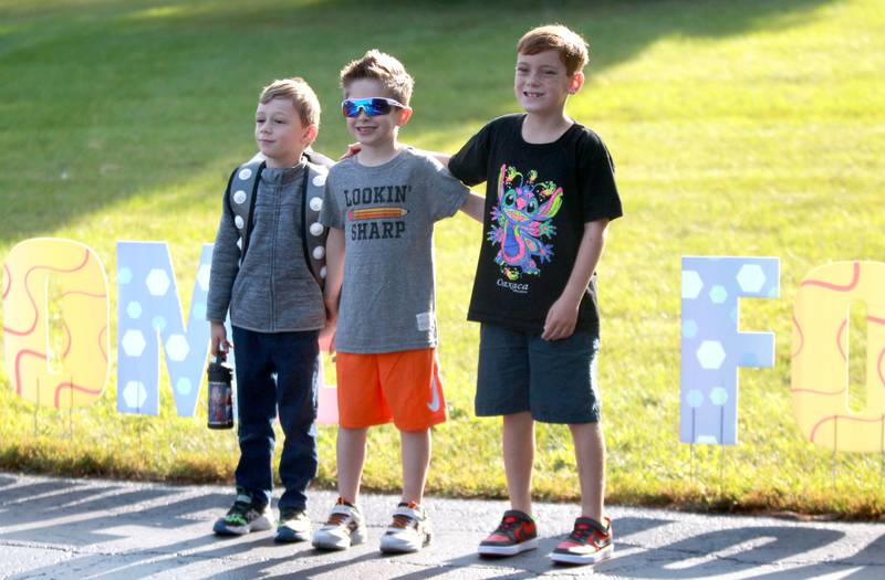 (Left to right) Kindergartner Raymond Timm, first grader Dylan Pflughaupt and third grader Bradley Gonzalez pose for a photo together on the first day of school at Fox Ridge Elementary School in St. Charles on Wednesday, Aug. 14, 2024.