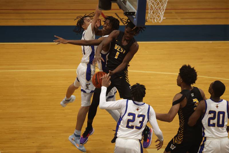 Joliet West’s Justus McNair battles for the rebound against Joliet Central.