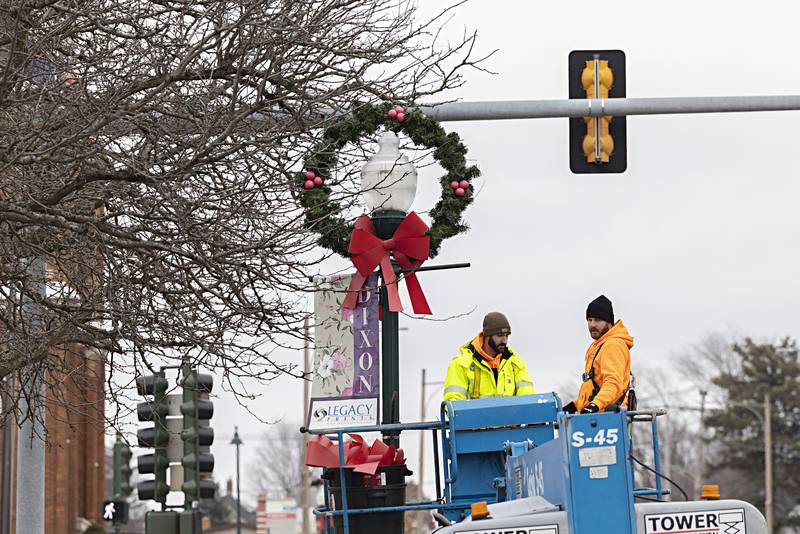 Dixon street department’s Steve Fassler (left) and Austin Clark work to remove the holiday decorations Wednesday, Jan. 3, 2024 from the downtown.