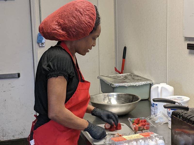Carla Christian, co-owner of L & J Mississippi BBQ in Plano, chops up strawberries for banana pudding, one of the popular items at the restaurant.