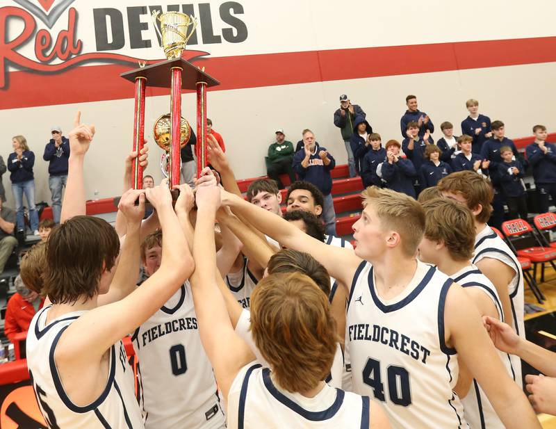 Members of the Fieldcrest basketball team hoist the the Colmone Classic first place trophy after defeating Rock Falls in the 49th annual Colmone Classic on Satruday, Dec. 9, 2023 at Hall High School.