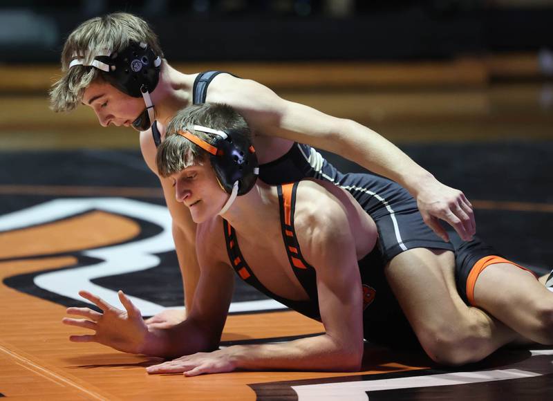 Sycamore’s Michael Olson (top) and DeKalb’s Owen Burgess wrestle Friday, Jan. 17, 2025, during their 120 pound match at DeKalb High School.