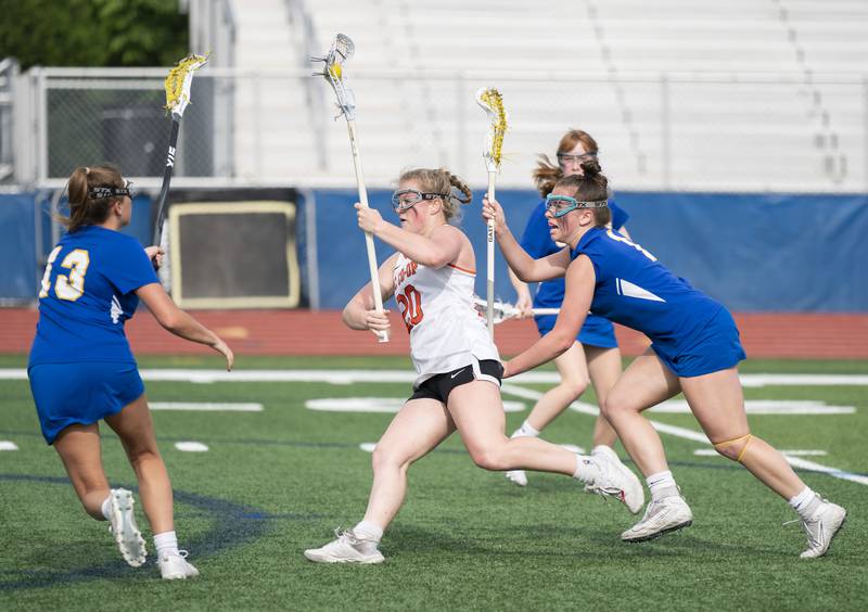 Crystal Lake Central's Maddi Lieflander runs with the ball through Lake Forest's Cate Lee, left, and Lissy Blume during the girls lacrosse supersectional match on Tuesday, May 31, 2022 at Hoffman Estates High School.