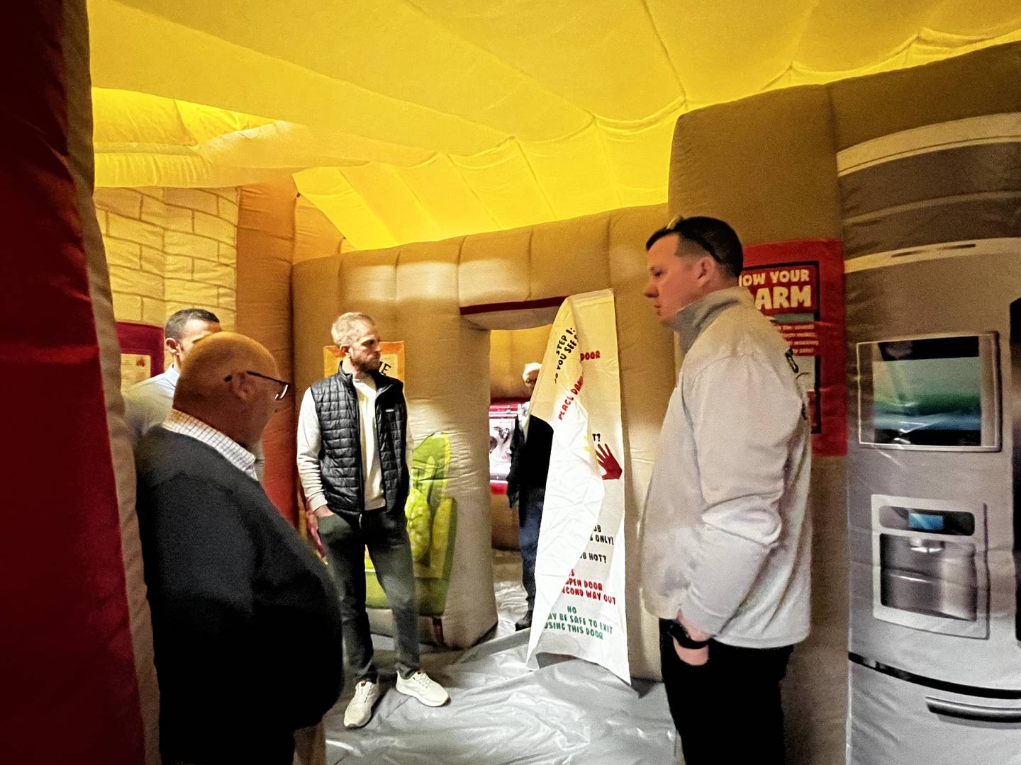 Ottawa Fire Chief Brian Bressner explains the new inflatable fire house to Rick Scott and Gentry Nordstrom.