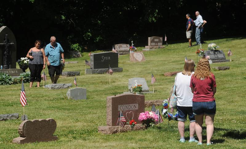 People walk about the Oswego Township Cemetery after the annual Memorial Day Parade and Service, Monday, May 29, 2023.