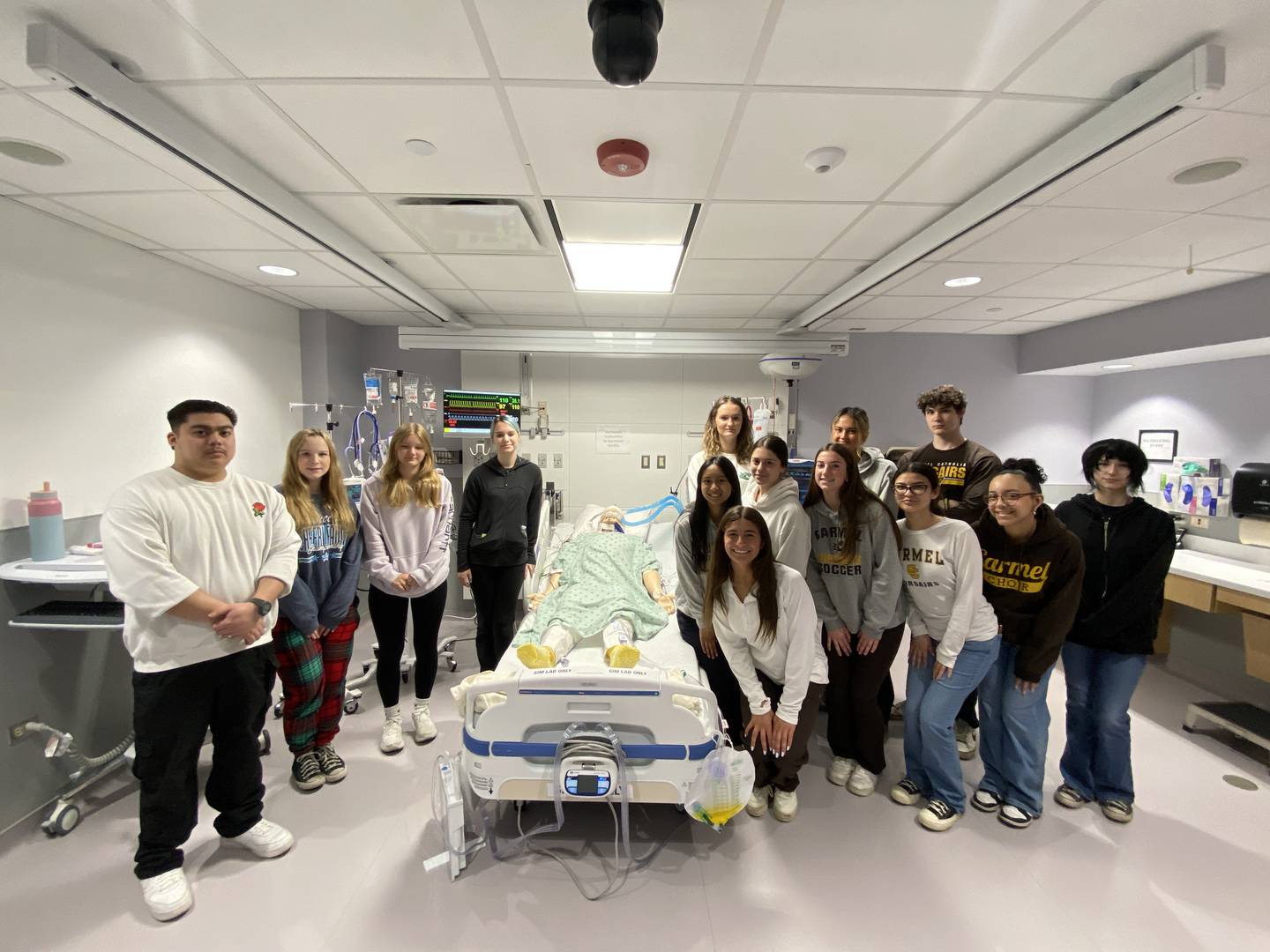 Students pose with a manakin in the simulation lab.