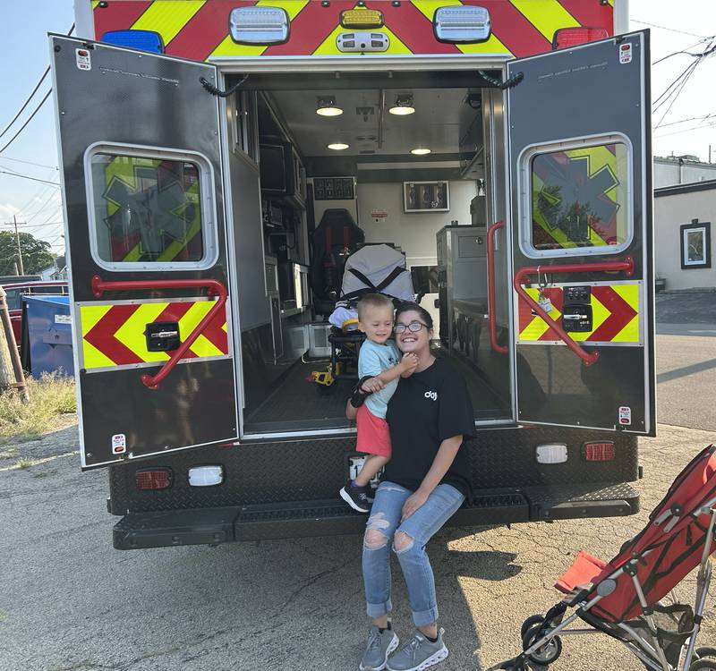Lindsey Knoup and AJ Kemp 3, sit in an Oregon Fire District Ambulance during National Night Out in Oregon on Tuesday, Aug. 5, 2025. The event was organized by the Oregon Police Department and included displays and trucks provided by the police, fire, and public works departments. AJ is the grandson of Oregon Fire Chief Michael Knoup.