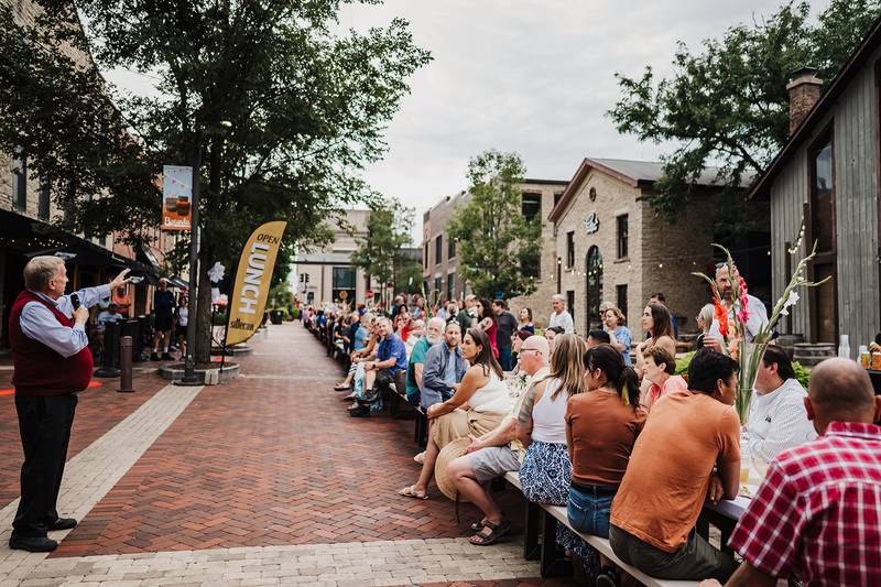 Attendees sit at one long table eating and socializing at Batavia United Way's 2023 Community Dinner Table event. The 2024 event will take place from 4 to 6 p.m. Sunday, Sept. 8, in downtown Batavia.