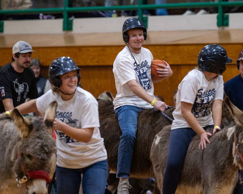 Members of 'Seneca FFA Officers and Alumni' ride down court in game of Donkey Basketball on Saturday, Feb. 7, 2026 at Seneca High School West Campus in Seneca.