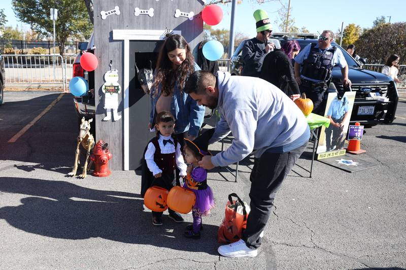 A father stops to fix his daughters hat at the Joliet Police Department Trunk-Or-Treat event on Saturday, Oct. 26, 2024 in Joliet.