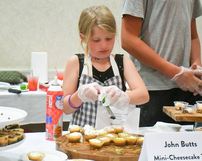 Grace Hoste, 8, of Sycamore helps put lime shavings on a key lime dessert during the 20th anniversary of 50 Men Who Cook, an annual fundraiser hosted by CASA DeKalb County at the Barsema Alumni and Visitors Center at Northern Illinois University in DeKalb on Saturday, Aug. 10, 2024.