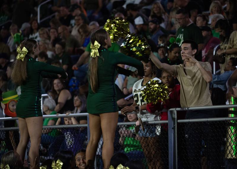 Bishop McNamara students toss pom-poms through baskets that the cheerleaders have made during a break in action in a game against Chicago Christian on Friday, September 19, 2025.