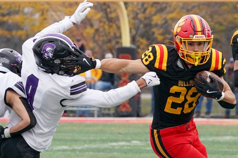 Batavia’s Nathan Whitwell (28) carries the ball and stiff arms Downers Grove North's Ethan Murphy (9) during a class 7A quarterfinal playoff football game at Batavia High School on Saturday, Nov. 16, 2024.