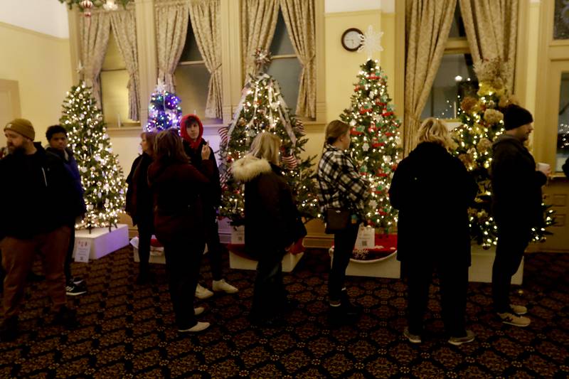 People look at Christmas trees in the Woodstock Opera House during the Lighting of the Square on Friday, Nov. 25, 2022, in Woodstock. The annual event featured brass music, caroling, free doughnuts and cider, food trucks, festive selfie stations and shopping.