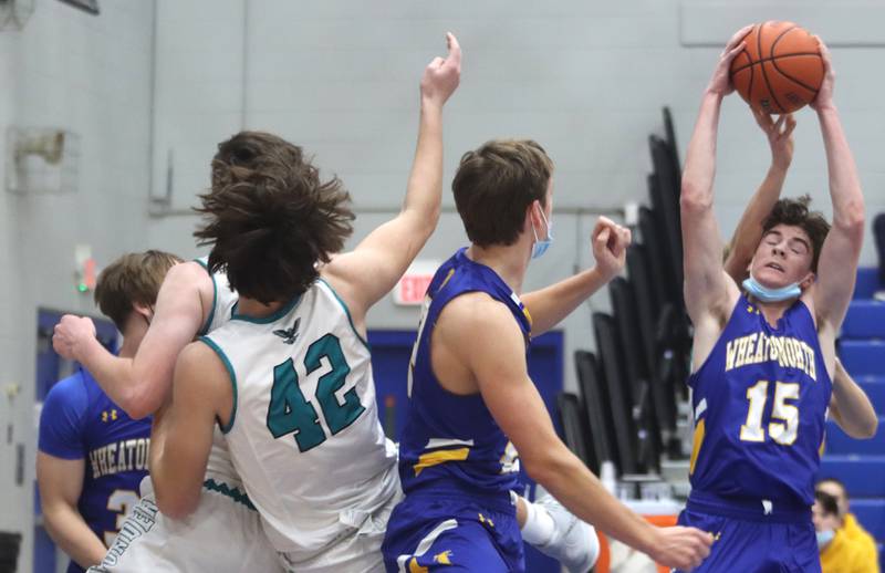 Wheaton North’s Eamon Kane snags a rebound against Woodstock North during MLK Tournament action at Burlington Central High School Saturday morning.
