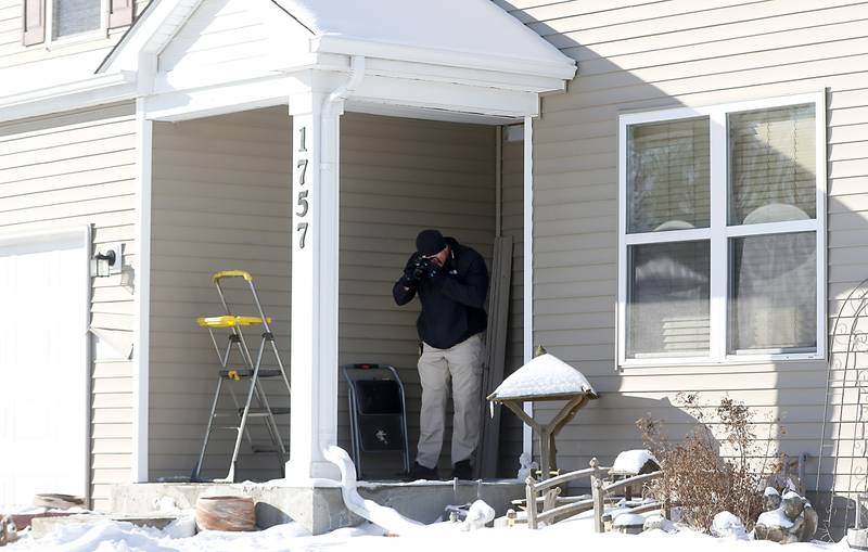 Woodstock Police Officer Josh Fourdyce collects evidence the morning of Tuesday, Jan. 25, 2022, after a shooting Monday evening, outside the in the home in the 1700 block of Yasgur Drive in Woodstock.