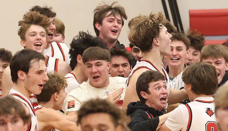 Members of the Hall boys basketball team react with teammates and students after beating Fieldcrest in overtime during the Colmone Classic on Friday, Dec. 12, 2025 at Hall High School.
