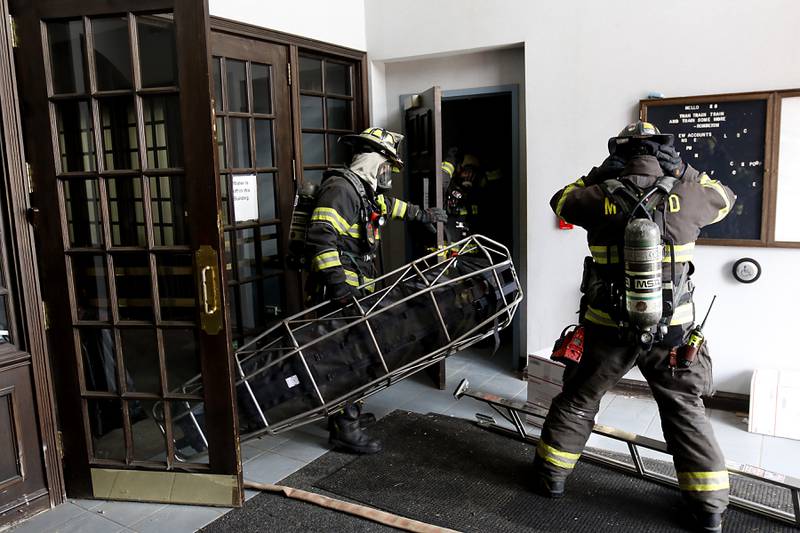 McHenry firefighters from RIT team two prepare to enter a smoke filled basement as they search for an injured firefighter on Tuesday April 15, 2025, during a RIT crew and chief divisional drill with other firefighters from area departments in a former bank building in Downtown McHenry.
