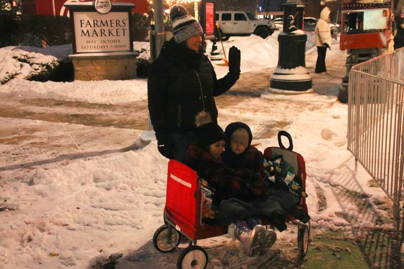 Heather, top, Kyndall Smith 5, bottom left, and Liam Karracker 4, bottom right, all of Kankakee, get cozy in their wagon while waching the Kankakee Christmas Parade on Saturday, Dec. 13, 2025.