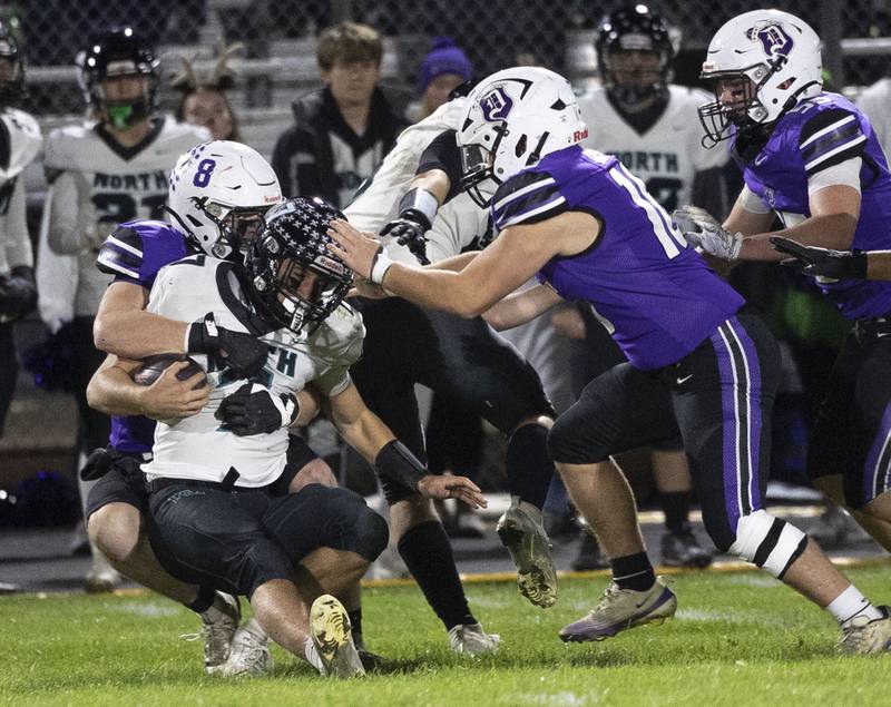 Dixon’s Bene Baratta hauls down Woodstock North’s Parker Halihan Friday, Oct. 31, 2025, in the Class 4A football first round playoffs.