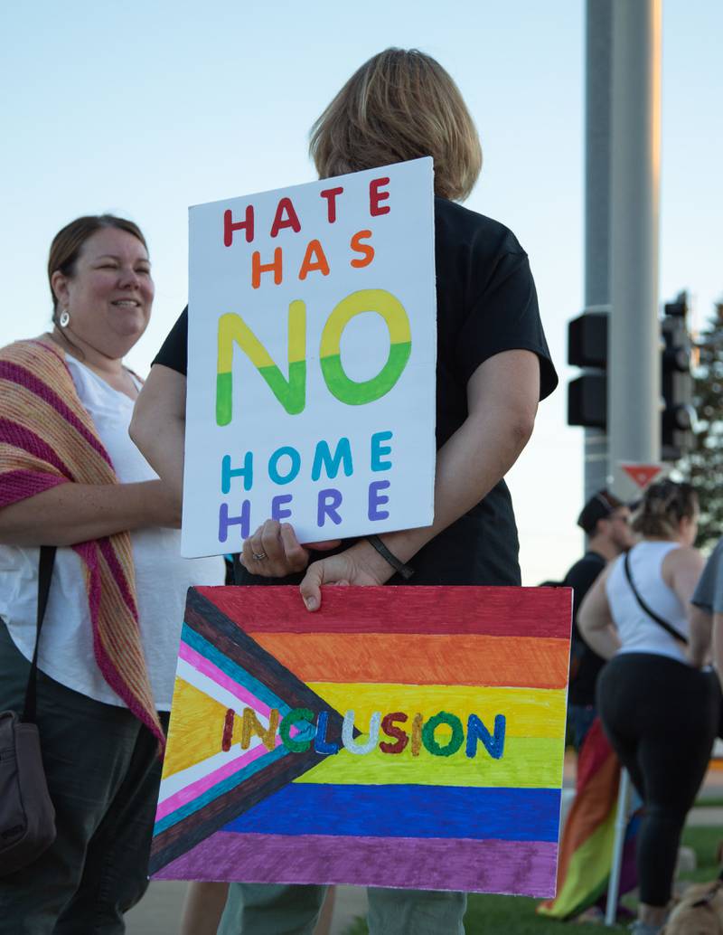 Chrissy Swanson of Geneva, the artist that painted the pride flag on the fire hydrant, holds signs during the Pride Fire Hydrant Rally at the northwest corner of Kirk Road and State Street/Rte. 38 in Geneva on Tuesday, Aug. 9, 2022.