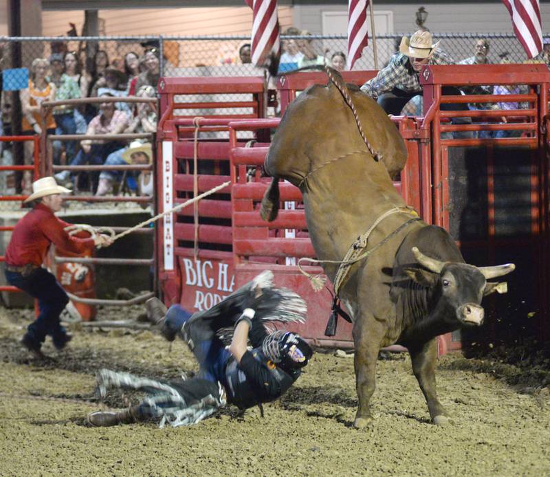 Drew Muhlenback, 19, of Bristol, Wisconsin, gets tossed by a bull at the Big Hat Rodeo at the Ogle County Fair on Friday, Aug. 2, 2024.