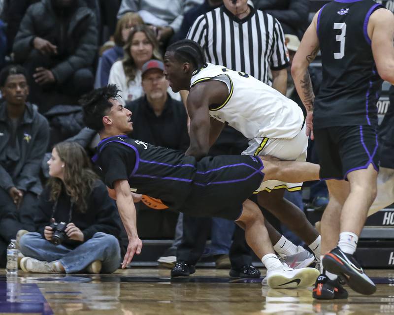 Plano's Alan Contreras (1) draws a charge from Yorkville Christian's Jayden Riley (3) during their Plano Christmas Classic semi-final basketball game between Yorkville Christian at Plano Monday, Dec 29, 2025 in Plano.