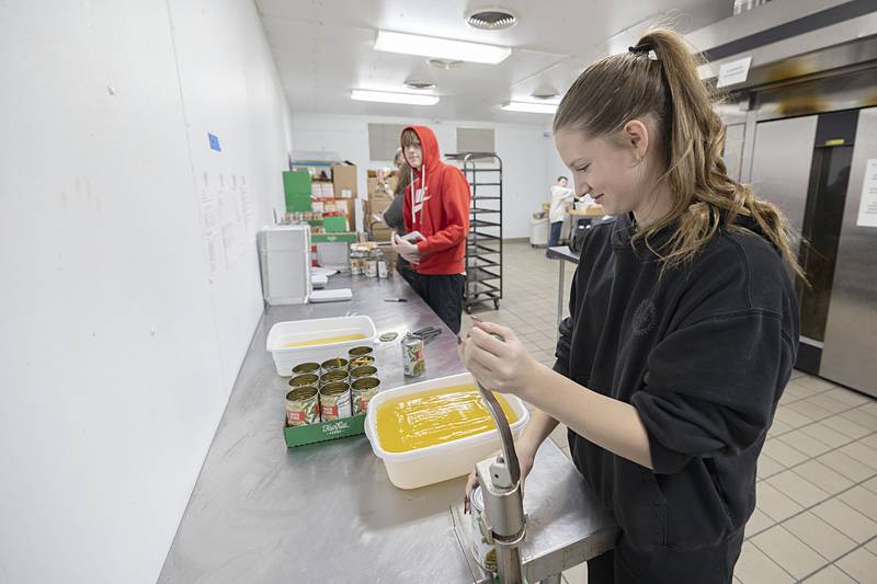 Sterling High School student Ruby Dingman opens cans of food Wednesday, Nov. 26, 2025, while volunteering as part of SVCC’s Impact program. A group of students helped prepare meals through the Path to the Future program organized through the Regional Office of Education.
