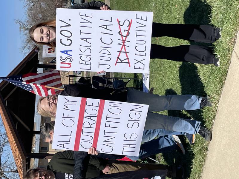 Protesters held signs as they lined up along 9th Street at City Square in downtown Lockport for a No Kings rally in opposition to the Trump administration on Saturday, March 28, 2026.