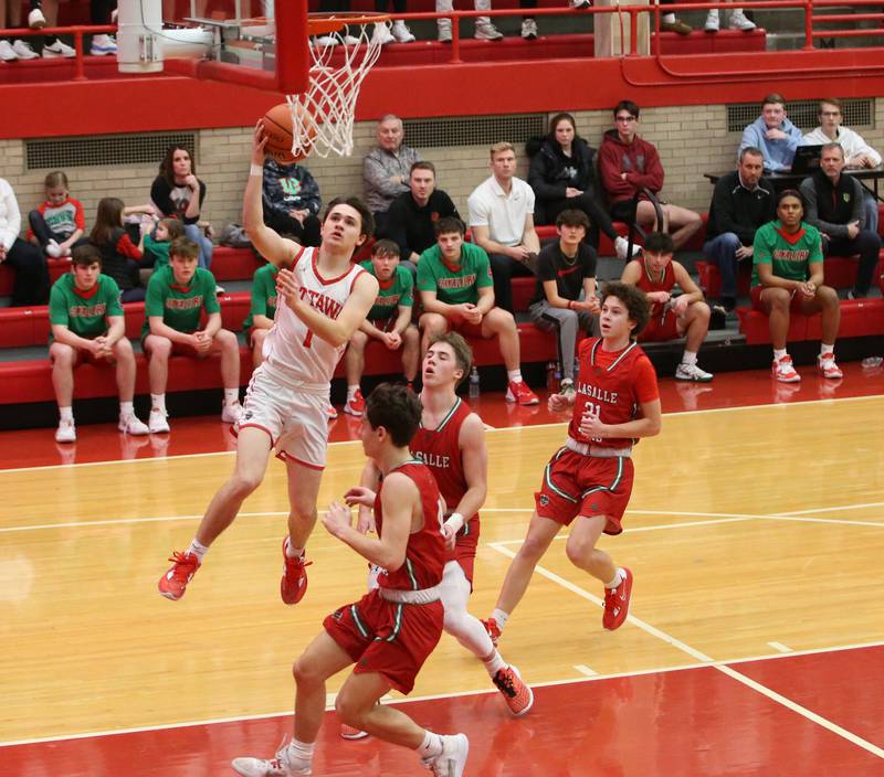 Ottawa's Connor Price scores on a drive to the basket over L-P's Jack Jereb, Seth Adams and Michael Hartman in Kingman Gymnasium on Friday, Feb. 10, 2023 at Ottawa High School.