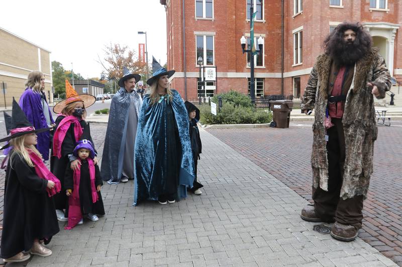 Rubeus Hagrid, portrayed by Todd Vandiver, of Janesville, Wi, gives directions to a family of witches and wizards walks through the historic Woodstock Square dressed as Rubeus Hagrid during the Witches and Wizards event on Sunday, Oct. 24, 2021 in Woodstock.