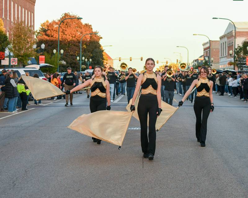 Sycamore High School Color Guard leads the marching band during the Homecoming Parade on Wednesday, Oct. 8, 2025, in downtown Sycamore.