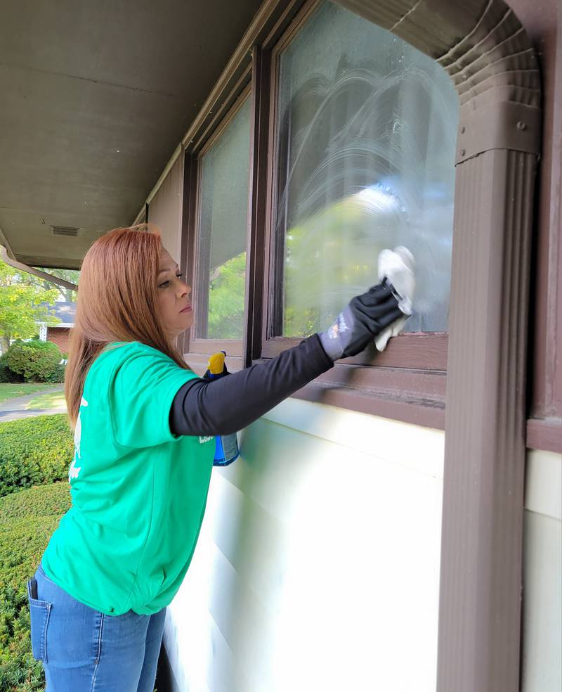 Barbara Seleski cleans the windows of a northwest Ottawa home, one of many Labor of Love projects performed on Saturday.