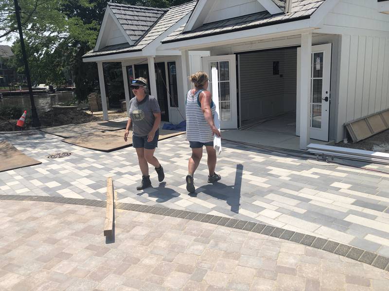 Amy Humbracht, left, the McHenry Riverwalk Shoppes Manager, and Molly Ostap, Chamber President, move lumber on Saturday, June 24, 2023, at McHenry's Riverwalk Shoppes. Construction began on May 1.