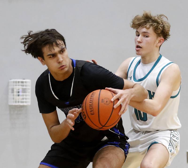 Woodstock's Spencer Cullum tries to drive to the basket against Woodstock North's Trevor Mark during a Kishwaukee River Conference boys basketball game on Friday, Jan. 5. 2024, at Woodstock North High School.