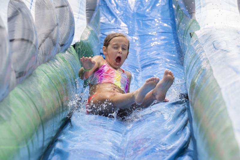 Sloane Perino, 8, skids down the water slide Thursday, June 15, 2023 during Dixon Park District’s SPARK Camp. Thursday marked the final day of the event for kids ages 7-9. Another camp is scheduled in July.