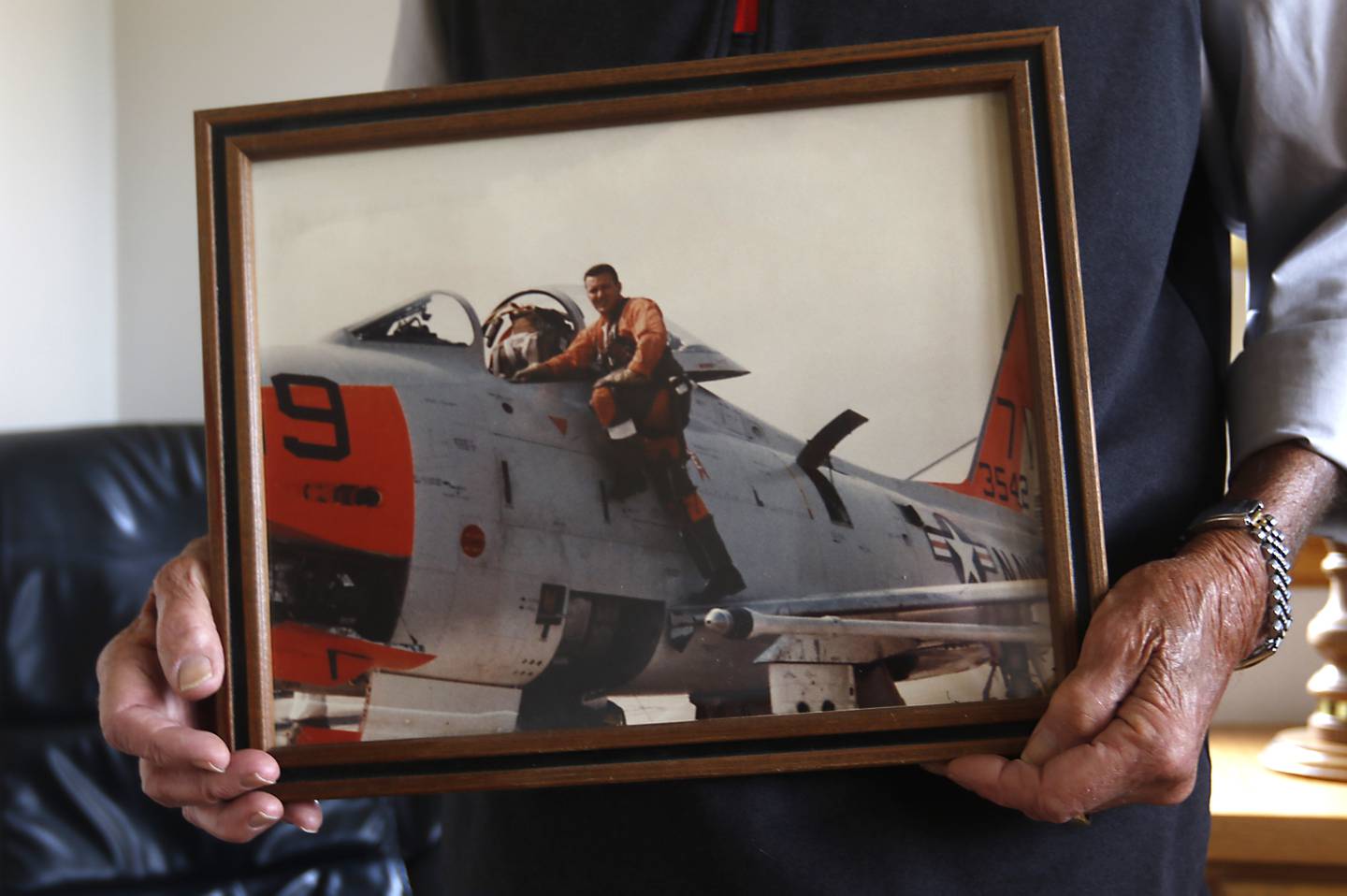 Retired U.S. Marine Corps pilot Paul Wember, 87, holds a photograph of his favorite plane a FJ-4 Fury on Monday, March 20, 2023, at his home in McHenry. Three generations of Wember men have "earned their wings" as pilots for the U.S. Marine Corps.