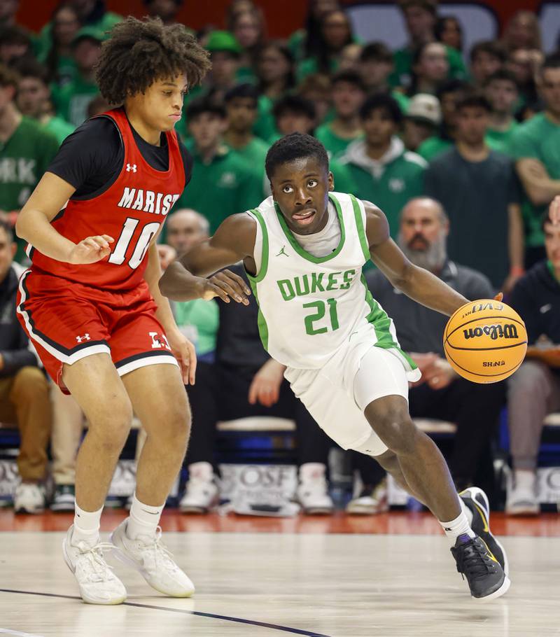 York’s Nathan Poku (21) slips past Marist's Jayden Bullock (10) during the IHSA Class 4A boys basketball state semifinal Friday, March 13, 2026 at the State Farm Center in Champaign.