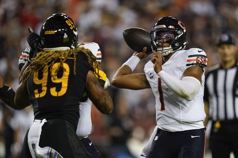 Chicago Bears quarterback Justin Fields passes while under pressure from Washington Commanders defensive end Chase Young during the first half, Thursday, Oct. 5, 2023, in Landover, Md.