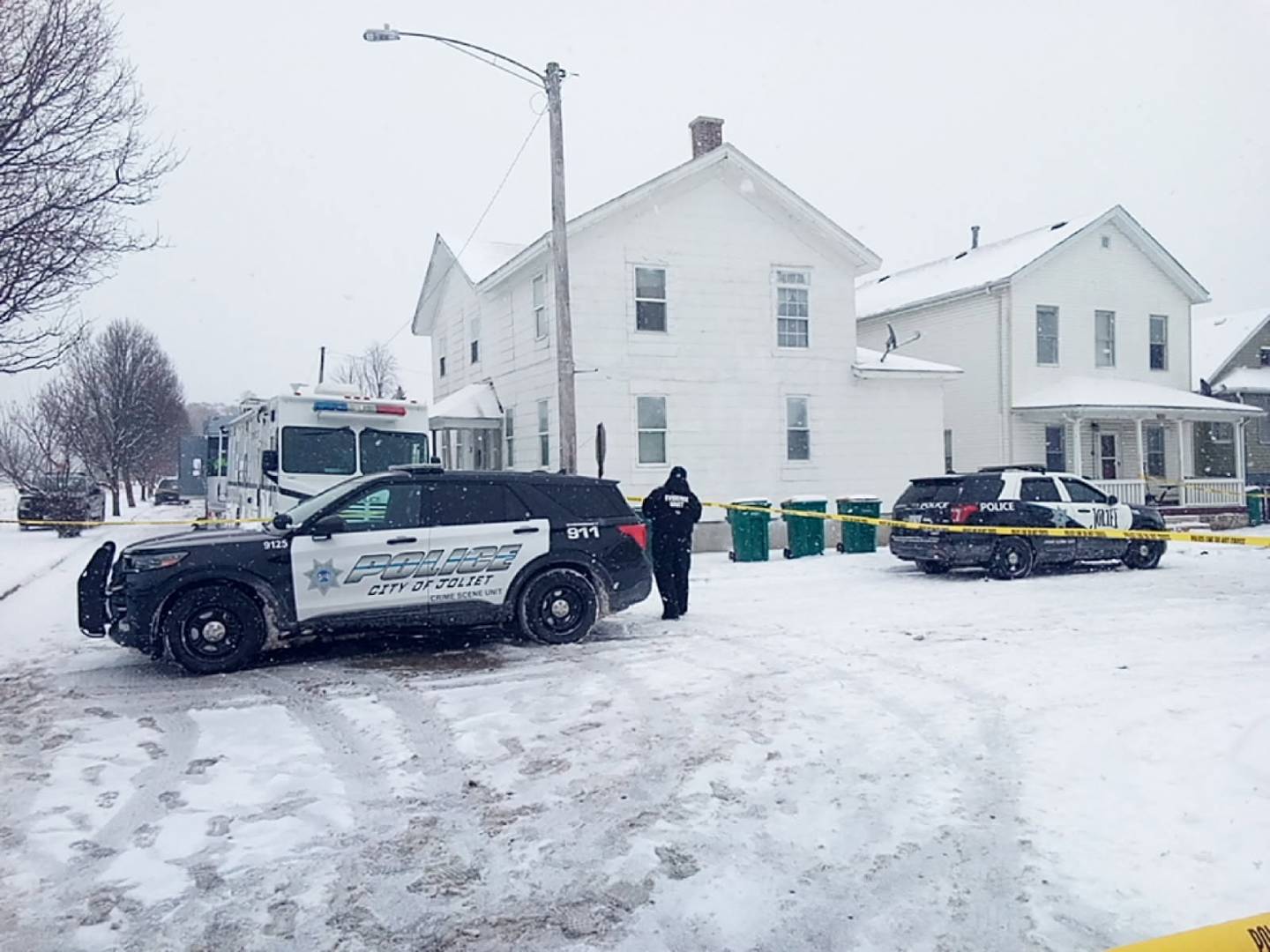 Joliet police vehicles block off the corner of Garnsey Avenue and Ward Street near a house where a 4-year-old boy and a 36-year-old woman were shot to death Sunday, Jan. 25, 2026.
